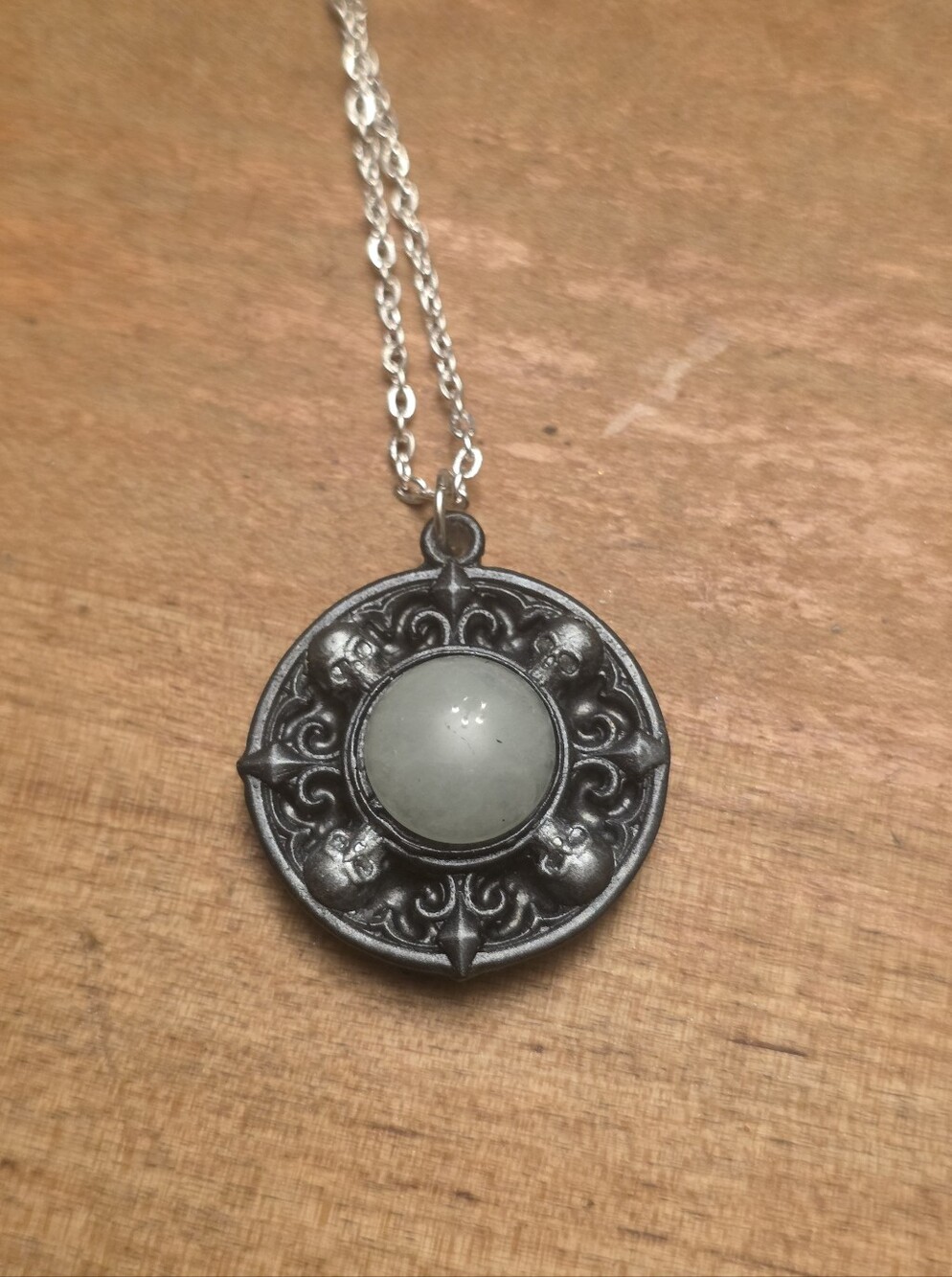 Round Skull Pendant With Central White Gemstone On A Silver Tone Chain Necklace